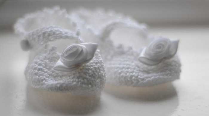Knitted newborn booties on a soft surface
