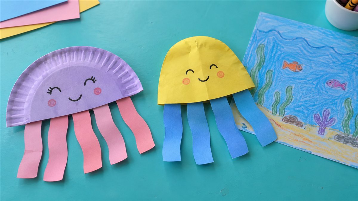 Jellyfish crafts for kids with short broad paper tentacles and an ocean drawing